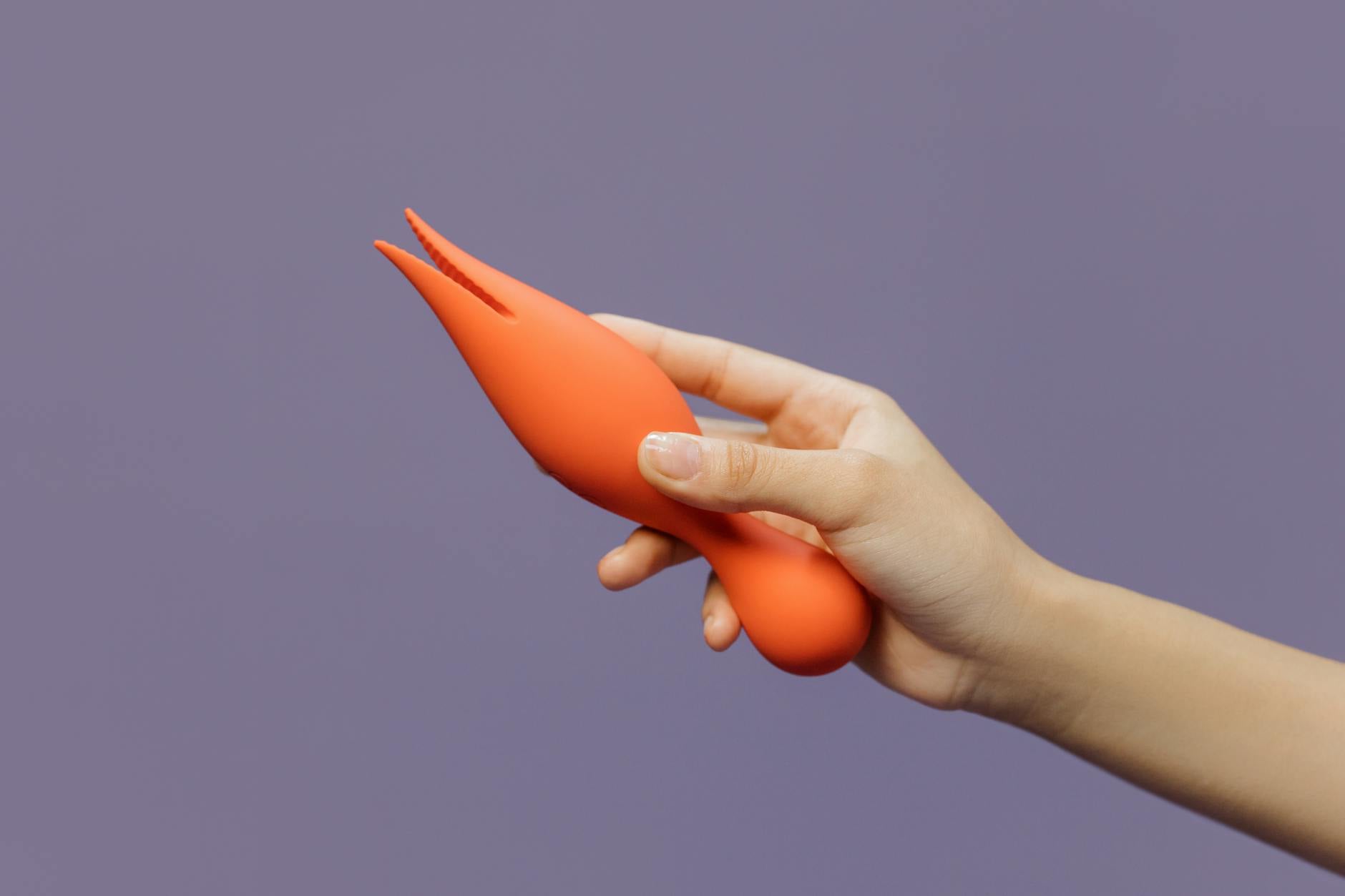 Hand holding a yellow lemon vibrator against a minimalist backdrop, representing safe, solo reclamation of pleasure.