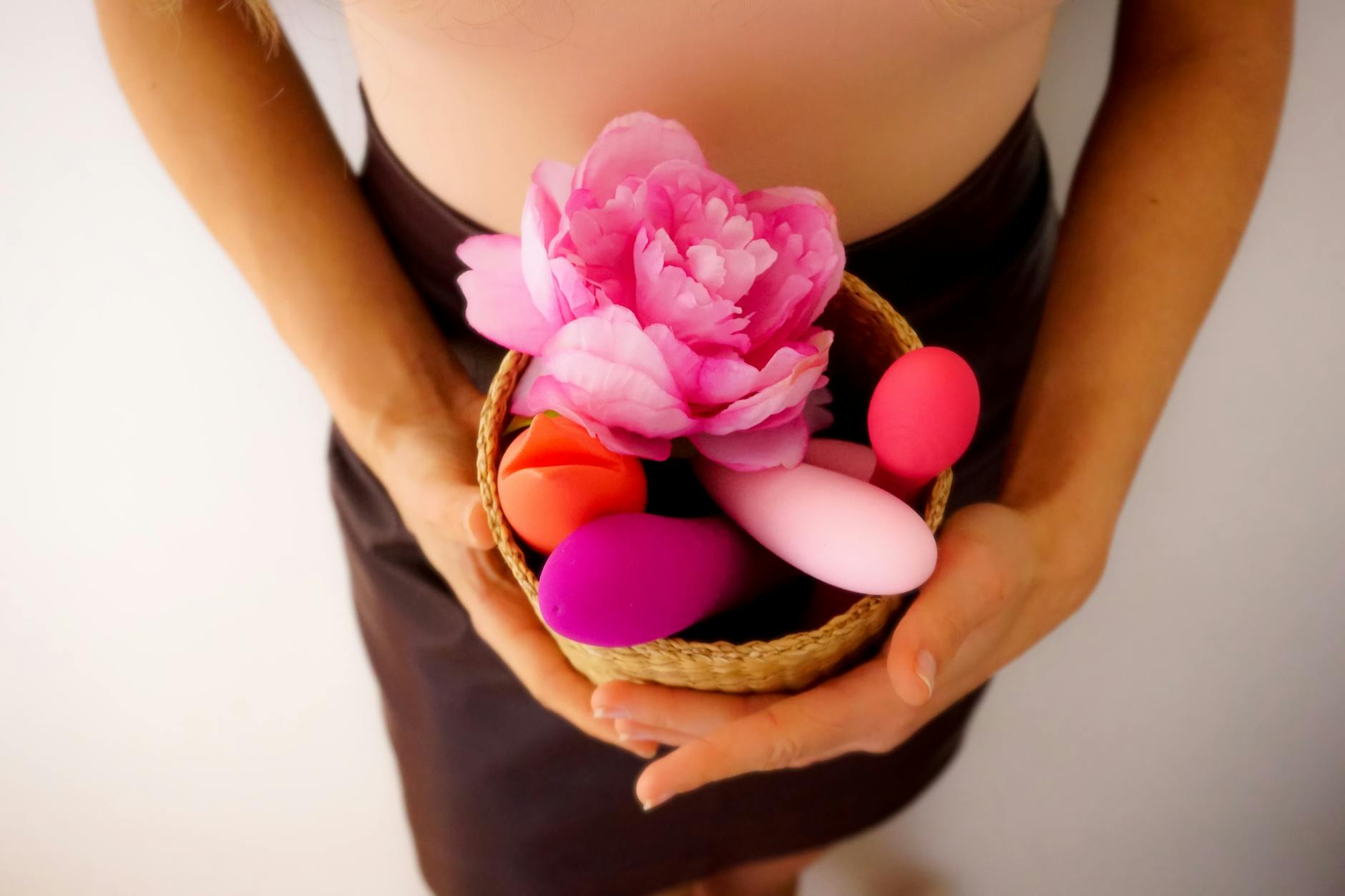 Woman holding blue and pink clitoral vibrators, ready to explore pleasure again